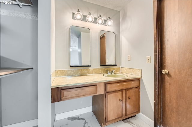 bathroom featuring vanity, baseboards, and marble finish floor