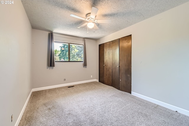 unfurnished bedroom with baseboards, carpet, a closet, and a textured ceiling