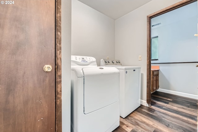 laundry area with washing machine and clothes dryer, laundry area, baseboards, and wood finished floors