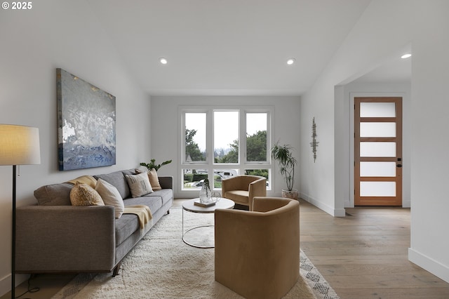 living room featuring vaulted ceiling and light hardwood / wood-style floors