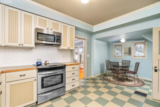 kitchen with appliances with stainless steel finishes, tasteful backsplash, and crown molding