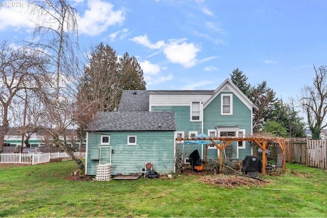 rear view of property featuring a pergola and a lawn