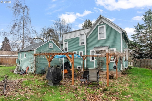 rear view of property featuring a yard and a pergola