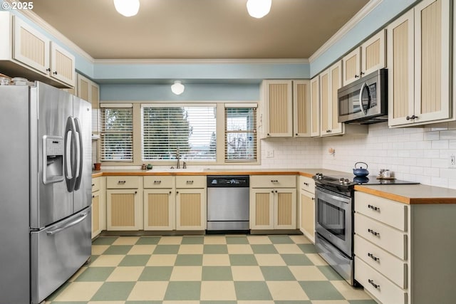 kitchen with sink, crown molding, stainless steel appliances, and decorative backsplash