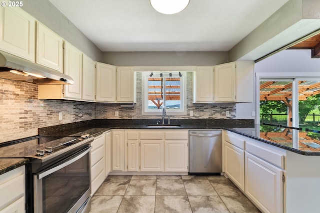 1770 Mccormick Loop Rd, Tillamook, OR 97141 - kitchen with stainless steel appliances, a sink, under cabinet range hood, decorative backsplash, and a peninsula