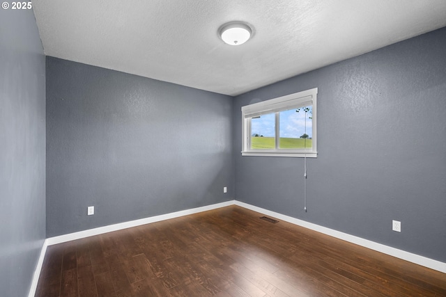 1770 Mccormick Loop Rd, Tillamook, OR 97141 - spare room with dark wood-style flooring, baseboards, a textured ceiling, and a textured wall