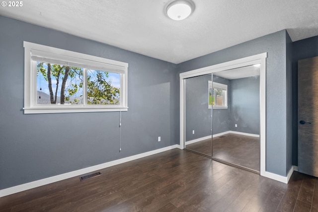1770 Mccormick Loop Rd, Tillamook, OR 97141 - unfurnished bedroom with wood finished floors, baseboards, a closet, and a textured ceiling