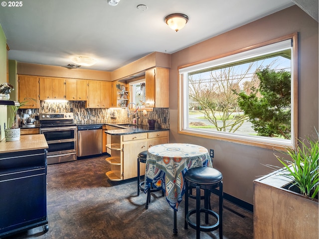 kitchen featuring dark countertops, open shelves, decorative backsplash, stainless steel appliances, and a sink