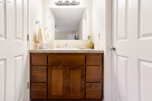 bathroom featuring vanity and decorative backsplash