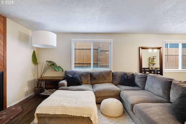 living area featuring a textured ceiling, dark wood-type flooring, and baseboards