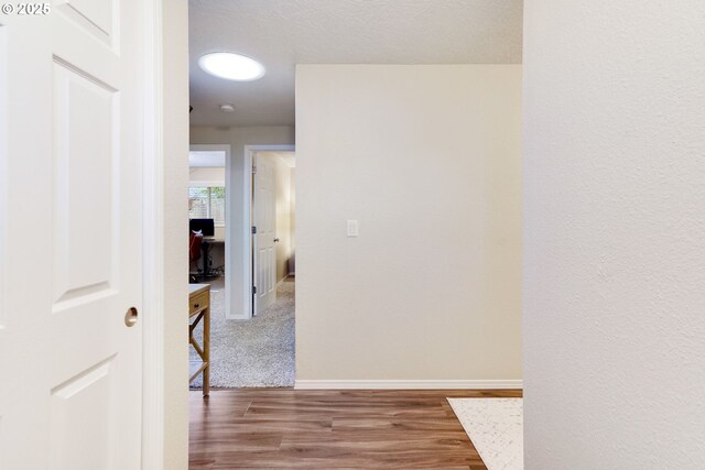 hallway with wood finished floors and baseboards