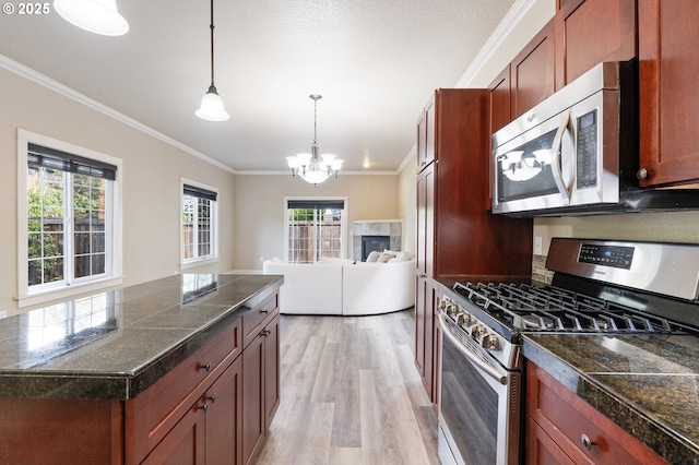 kitchen featuring stainless steel appliances, tile countertops, crown molding, light wood-type flooring, and a chandelier