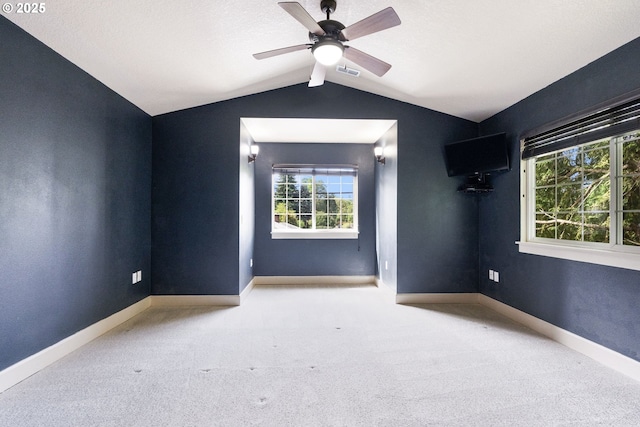empty room featuring carpet, vaulted ceiling, ceiling fan, and baseboards