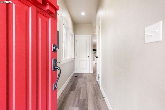 corridor featuring wood finished floors, baseboards, and recessed lighting