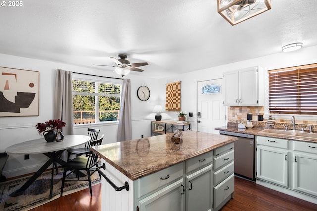 kitchen featuring sink, a center island, dark hardwood / wood-style flooring, dishwasher, and decorative backsplash