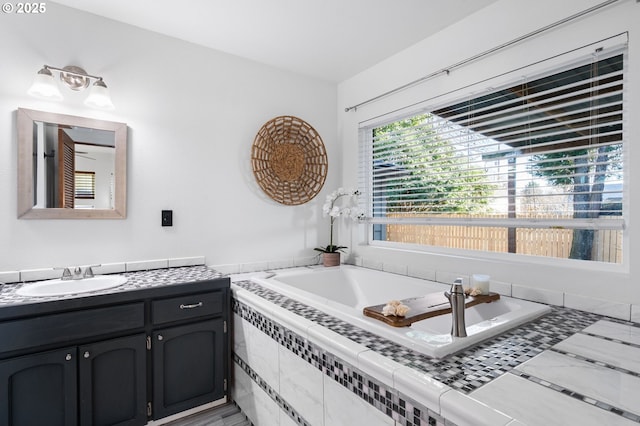 bathroom featuring vanity and tiled bath