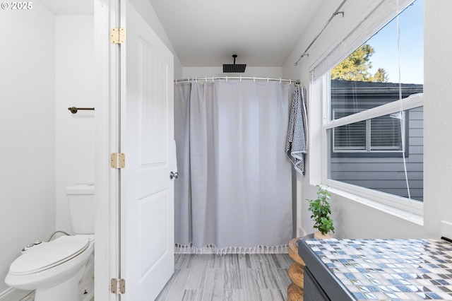 bathroom featuring toilet and walk in shower