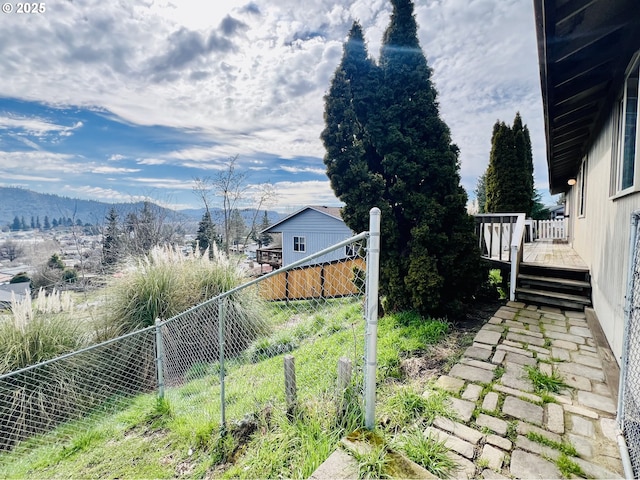 view of yard with fence and a deck with mountain view