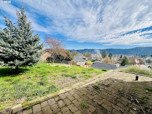 view of yard featuring a patio area, a mountain view, and fence