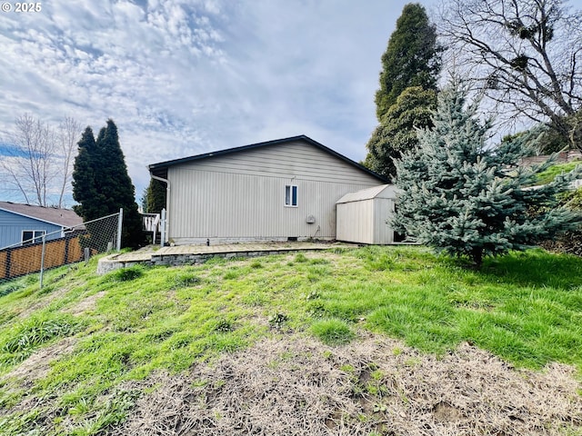 exterior space featuring an outbuilding, fence, and a storage unit