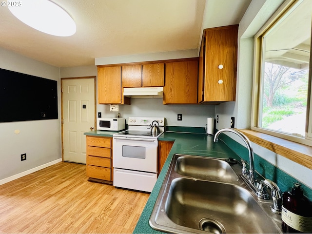 kitchen with brown cabinets, light wood-style floors, a sink, white appliances, and under cabinet range hood