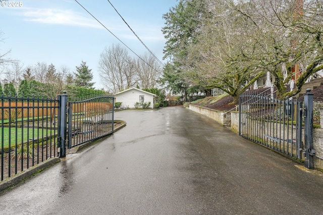 view of road with a gate, a gated entry, and aphalt driveway