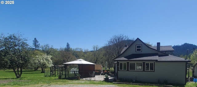 exterior space with a gazebo, a yard, and a chimney