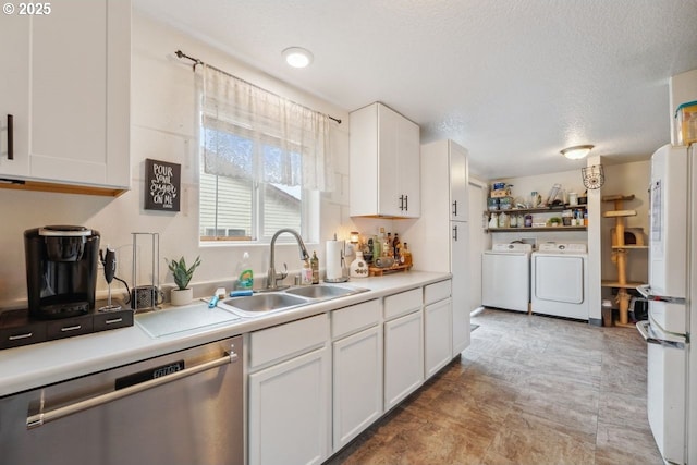 kitchen featuring white cabinets, washing machine and dryer, light countertops, and stainless steel dishwasher