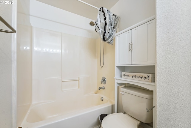 full bathroom featuring toilet, shower / bath combo, and a textured wall