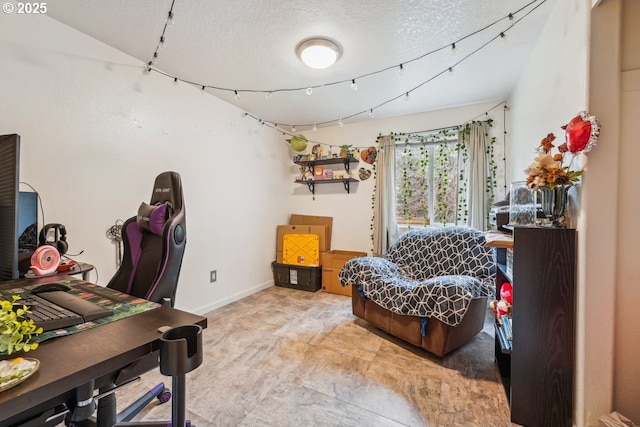 office featuring track lighting, baseboards, and a textured ceiling