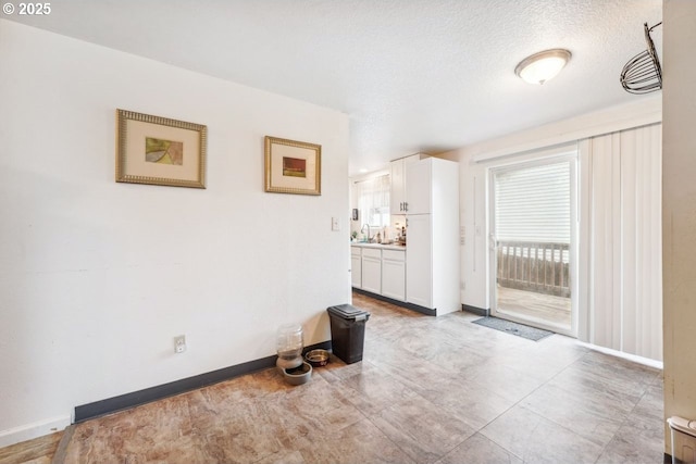 interior space featuring a wealth of natural light, a sink, and baseboards