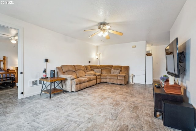 living area featuring ceiling fan and a textured ceiling