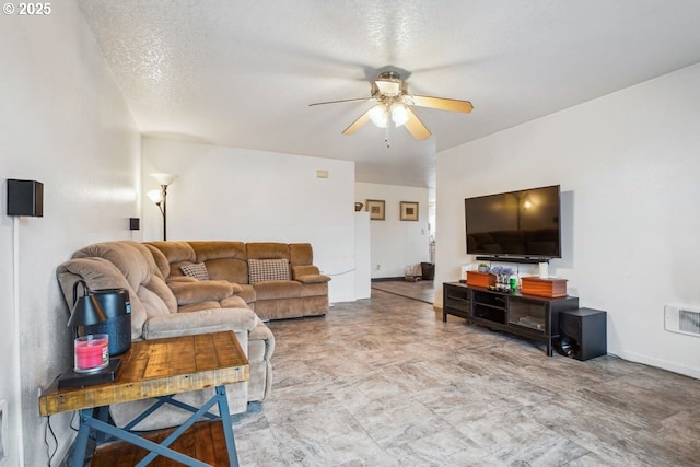 living room with a ceiling fan, visible vents, and a textured ceiling