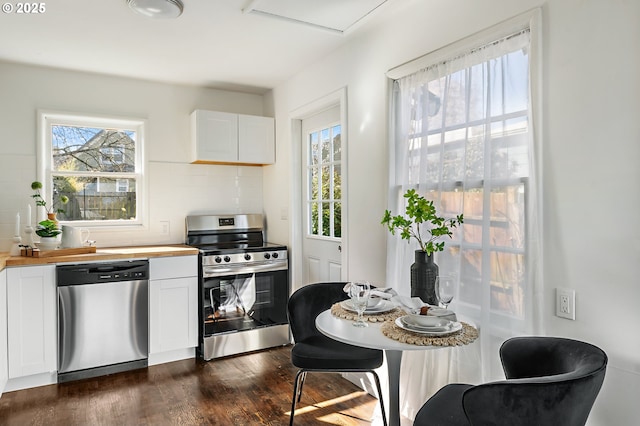 kitchen with tasteful backsplash, dark wood finished floors, stainless steel appliances, white cabinetry, and wooden counters