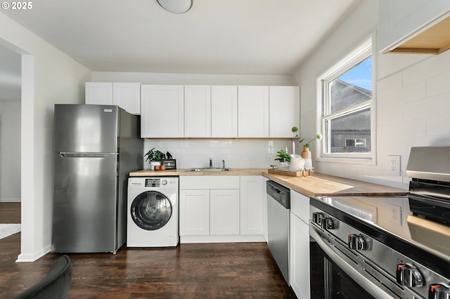 kitchen with washer / dryer, tasteful backsplash, dark wood-style floors, butcher block counters, and stainless steel appliances