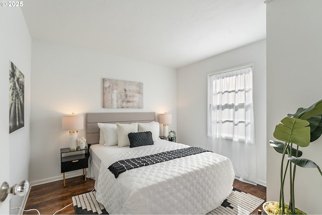 bedroom with baseboards and wood finished floors