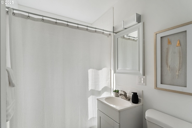 bathroom featuring curtained shower, vanity, and toilet