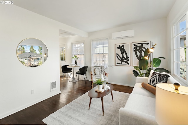 living room with baseboards, visible vents, wood finished floors, and a wall mounted air conditioner