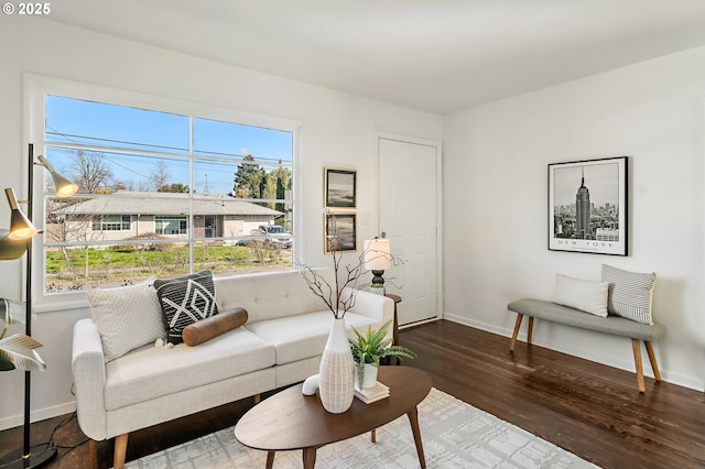 living area with baseboards and wood finished floors