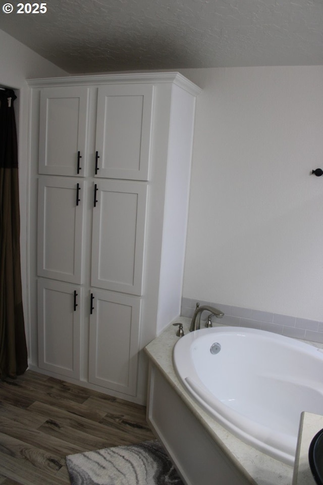 526 SE 15th St, Pendleton, OR 97801 - bathroom featuring a garden tub, wood finished floors, and a textured ceiling