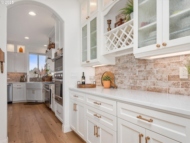 kitchen with tasteful backsplash, white cabinetry, and sink