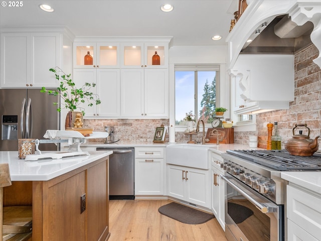 kitchen featuring stainless steel appliances, white cabinetry, sink, and decorative backsplash