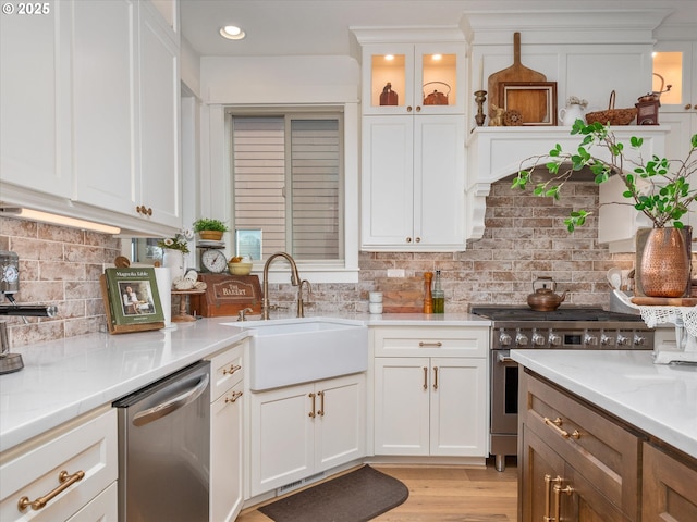 kitchen with light stone countertops, appliances with stainless steel finishes, sink, and white cabinets