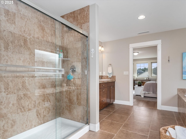 bathroom with tile patterned flooring, vanity, and walk in shower