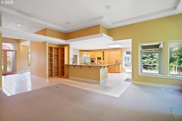 22040 Shannon Pl, West Linn, OR 97068 - kitchen featuring light tile patterned floors, light carpet, a peninsula, stainless steel appliances, and a kitchen bar