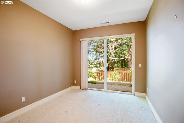 doorway featuring light colored carpet and baseboards