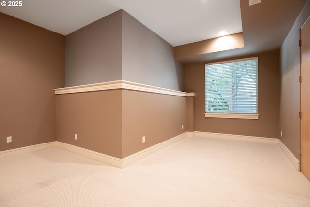 unfurnished room featuring carpet and baseboards