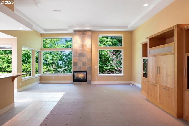 22040 Shannon Pl, West Linn, OR 97068 - unfurnished living room featuring a raised ceiling, healthy amount of natural light, a fireplace, recessed lighting, and baseboards