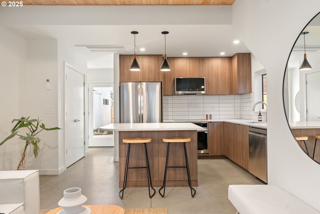 2291 N Humboldt St, Portland, OR 97217 - kitchen with appliances with stainless steel finishes, brown cabinetry, tasteful backsplash, modern cabinets, and recessed lighting