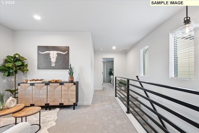 hall featuring light colored carpet